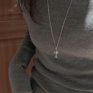 Collier en argent sterling S925 avec pendentif champignon sur un pull gris chic