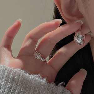 Detail view of S925 sterling silver hoop earrings and twisted ring with retro floral patterns