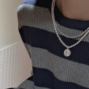 Close-up of double-layered S925 silver necklace with white pearls and coin pendant