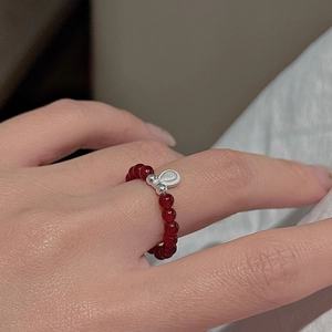 Detail of red beaded S925 sterling silver ring with silver teardrop charm on hand