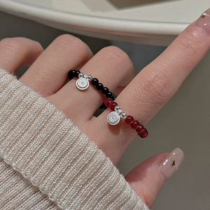 Minimalist S925 sterling silver beaded rings with black and red beads on a model's hand