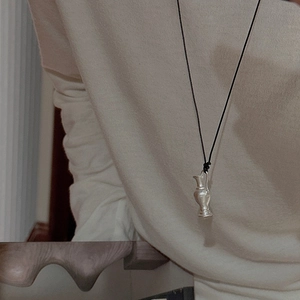 Minimalist S925 sterling silver matte vase pendant necklace on beige sweater background