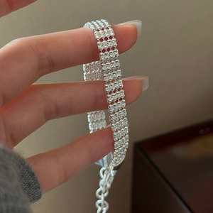 Close-up of four-row silver beaded bracelet with adjustable chain and polished texture