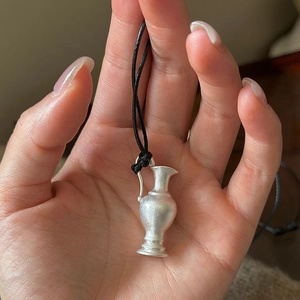 Minimalist S925 silver vase pendant with a matte finish held in hand for scale