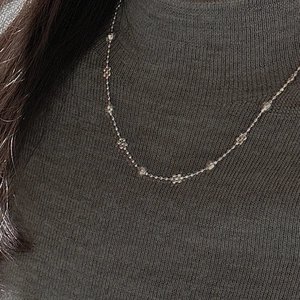 Collier minimaliste en argent S925 avec perles et breloques de fleurs sur tricot gris