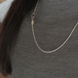 S925 Sterling Silver twist rope chain necklace worn on a grey knitted sweater