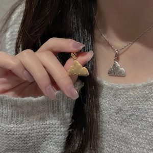 Detailed close-up of a matte silver cloud pendant on a necklace worn by a female model