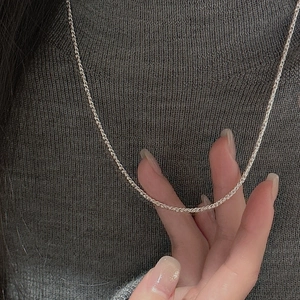 Detailed view of S925 sterling silver rope chain necklace worn on a grey sweater