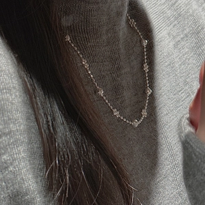 Détail d'un collier en argent S925 avec perles laser sur un col roulé gris chiné