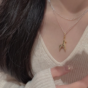 Detail showing a golden unicorn horse pendant on a double-layer S925 silver necklace