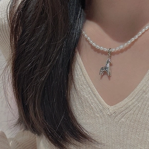 Elegant S925 silver horse pendant on a white pearl necklace worn by a model