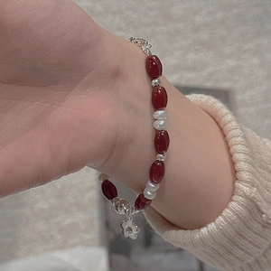 Detail of S925 silver beaded bracelet with red agate, freshwater pearls and floral charm