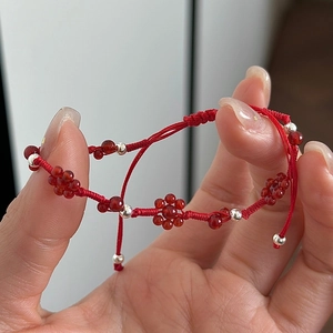 Handmade red cord woven bracelet featuring silver beads and agate floral accents