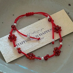Handmade woven red string bracelet with silver beads and flower pattern in adjustable fit