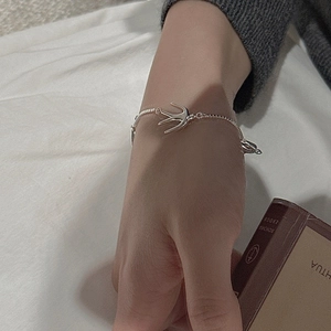 Close-up of S925 sterling silver swallow charm bracelet worn on a female wrist