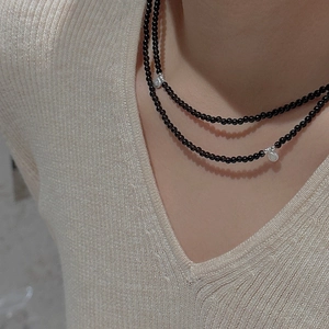 Close-up of double-layered black beaded necklace with silver baroque pearl pendants