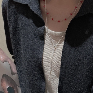 Detail of layered S925 silver twist necklaces on model wearing black knit sweater