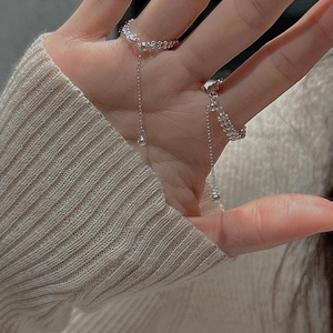 Dettaglio macro di un anello flessibile in argento S925 con nappa lunga e perline d'argento