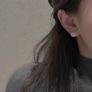 Close-up of elegant S925 silver pearl earring worn for a minimalist and refined look