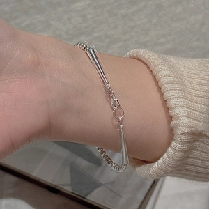 Dettaglio del bracciale a sfere in argento con ciondoli conici sul polso