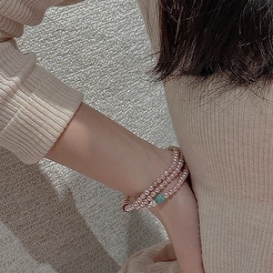 Close-up of S925 silver triple-layer pink pearl bracelet with green bead accent