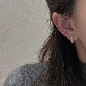 Créoles minimalistes en argent sterling S925 portées par un mannequin au style chic