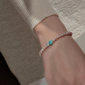 Close-up of S925 silver beaded bracelet with mini pearls and a blue cat-eye stone