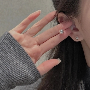 Gros plan de boucles d'oreilles en argent S925 avec zircons ronds portées par un mannequin