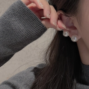 Close-up of elegant S925 silver double pearl earrings worn on a model's ear