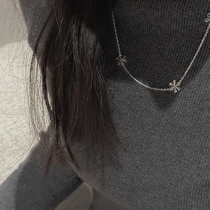 Minimalist S925 sterling silver necklace with five-petal flower charms on grey knit sweater