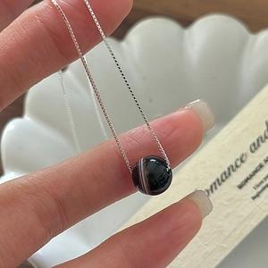 Détail du collier S925 en argent sterling avec pendentif agate rayée sur la main