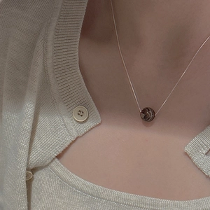 Close-up of minimalist S925 silver beaded necklace with striped agate stone pendant