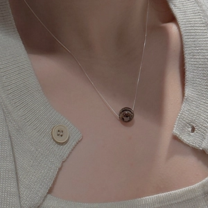 Detail of S925 sterling silver necklace featuring a natural textured bead on a model