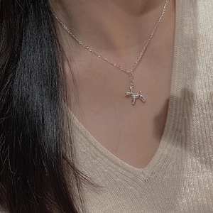 Close-up of S925 sterling silver balloon dog pendant on model with beige knitwear