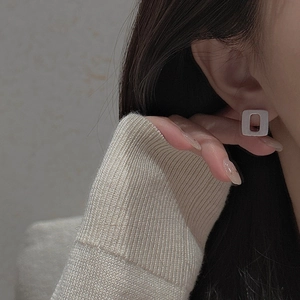 Macro shot of silver square hollow earrings on model for a minimalist geometric look