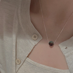 Close-up of S925 silver beaded necklace with a green marble pendant on a model