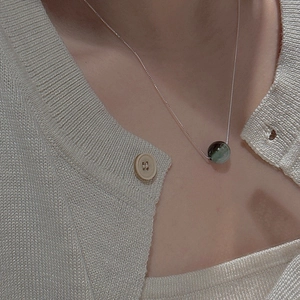 Elegant S925 silver beaded necklace with round green gemstone on beige knitwear