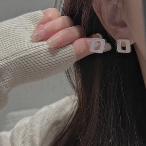 Close-up of S925 sterling silver square stud earrings with brushed matte finish on ear