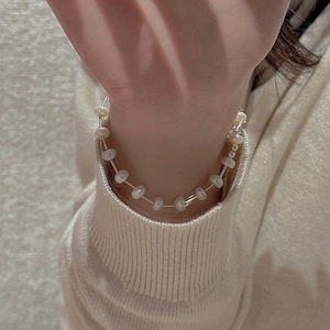 Detail view of S925 sterling silver pearl bracelet with metal tubes on a model wrist