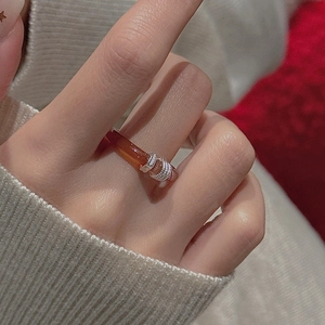 Gros plan sur bague en argent S925 et agate rouge sur fond de pull beige