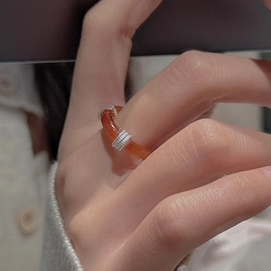 Gros plan d'une bague en agate rouge vintage avec des anneaux argentés sur une main