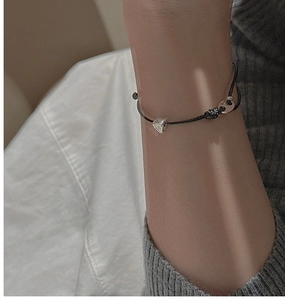 Détail du charm cœur en argent S925 sur bracelet cordon noir réglable porté au poignet