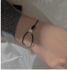 Détail de la boucle ovale en argent S925 sur un bracelet minimaliste en cordon noir
