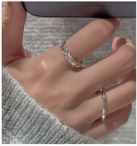 Detailed view of S925 silver rings set with irregular hammered texture and wave design