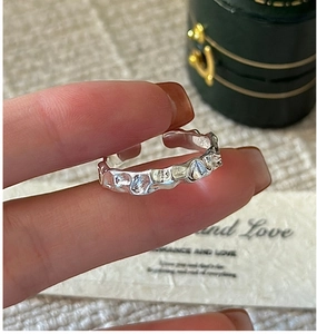 Detail of S925 sterling silver ring with irregular hammered texture and open design