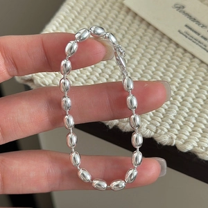 Minimalist S925 sterling silver rice bead bracelet with lobster clasp held by hand