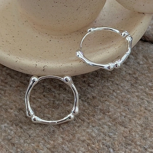 S925 sterling silver bamboo style hoop earrings on a natural ceramic background