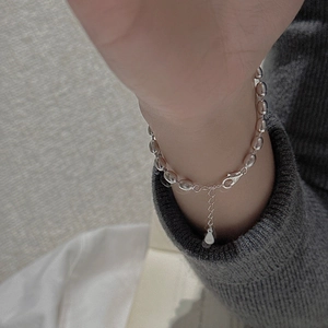 Close-up of minimalist S925 sterling silver beaded bracelet with adjustable drop charm