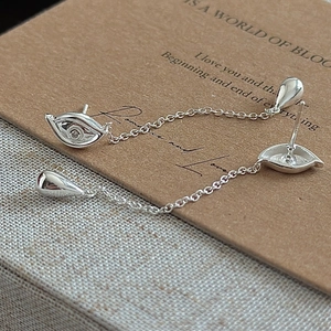 S925 sterling silver evil eye earrings with drop pendant on vintage paper background