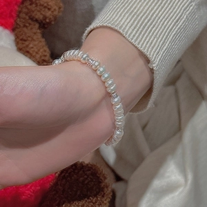 Detail eines Perlenarmbands aus s925 Silber mit Süßwasserperlen am Handgelenk eines Models
